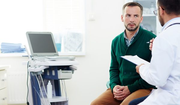 Serious patient listening to advice of professional practitioner after examination